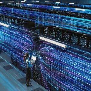 3D Graphics Concept: Big Data Center Female Chief Technology Officer Using Laptop Standing In Warehouse, Activates Servers, Information Digitalization Starts. SAAS, Cloud Computing, Online Service